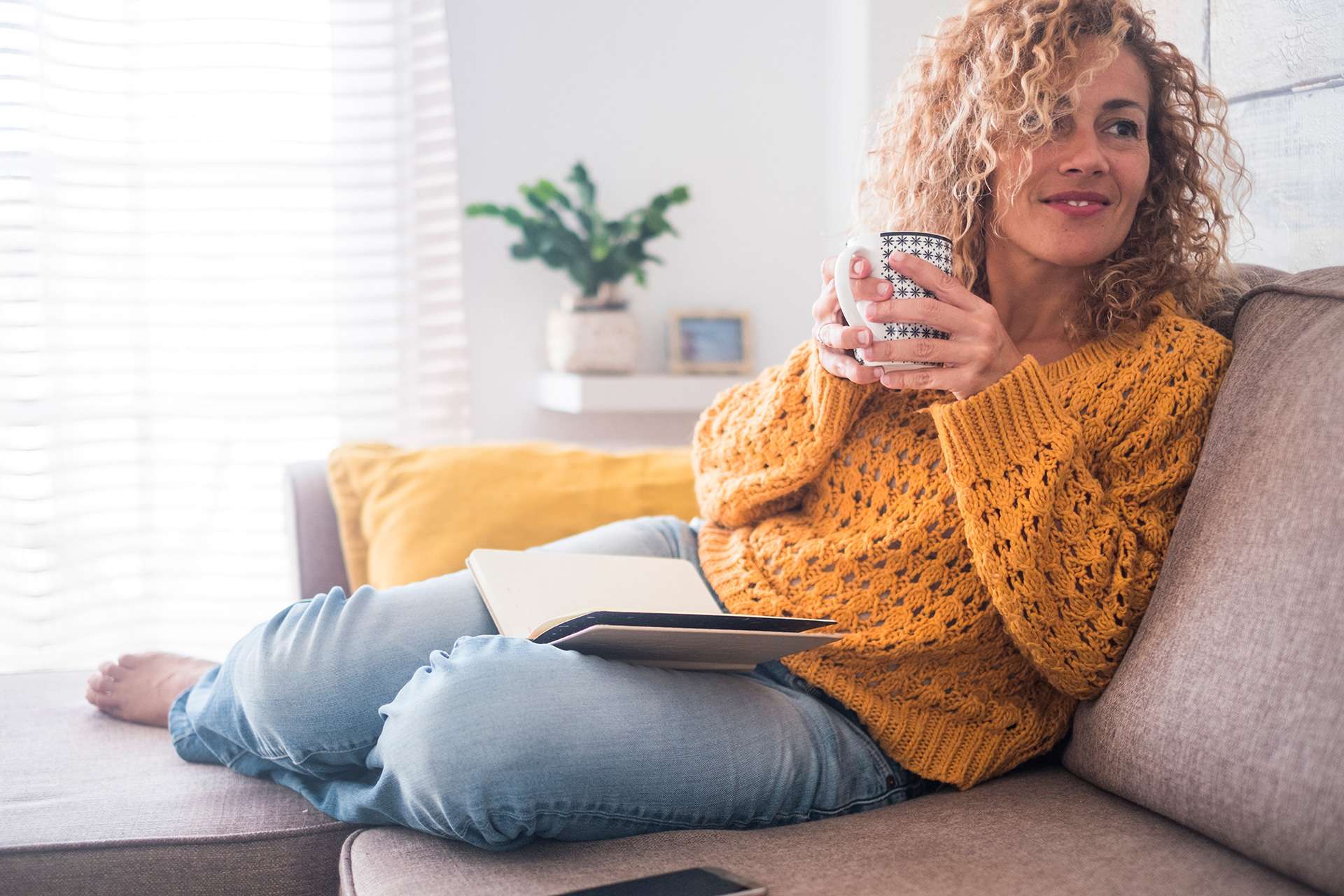 femme buvant un café sur un canapé confortable